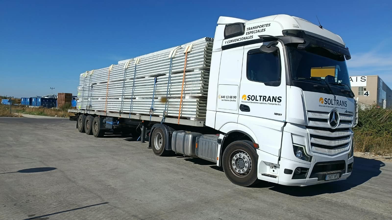 Camión SOLTRANS con estructuras metálicas en plataforma abierta